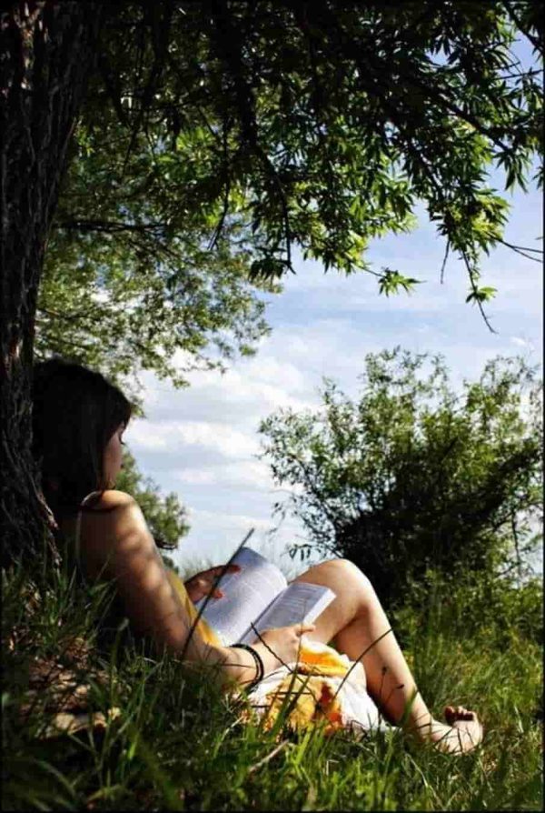 عکس دختر در حال خواندن در طبیعت